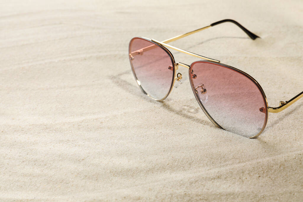 Stylish sunglasses on sand, closeup. Space for text - Foto, imagen