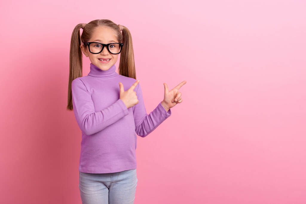 Photo of charming cute little schoolgirl in eyeglasses promote oculist services isolated on pink color background. - Zdjęcie, obraz