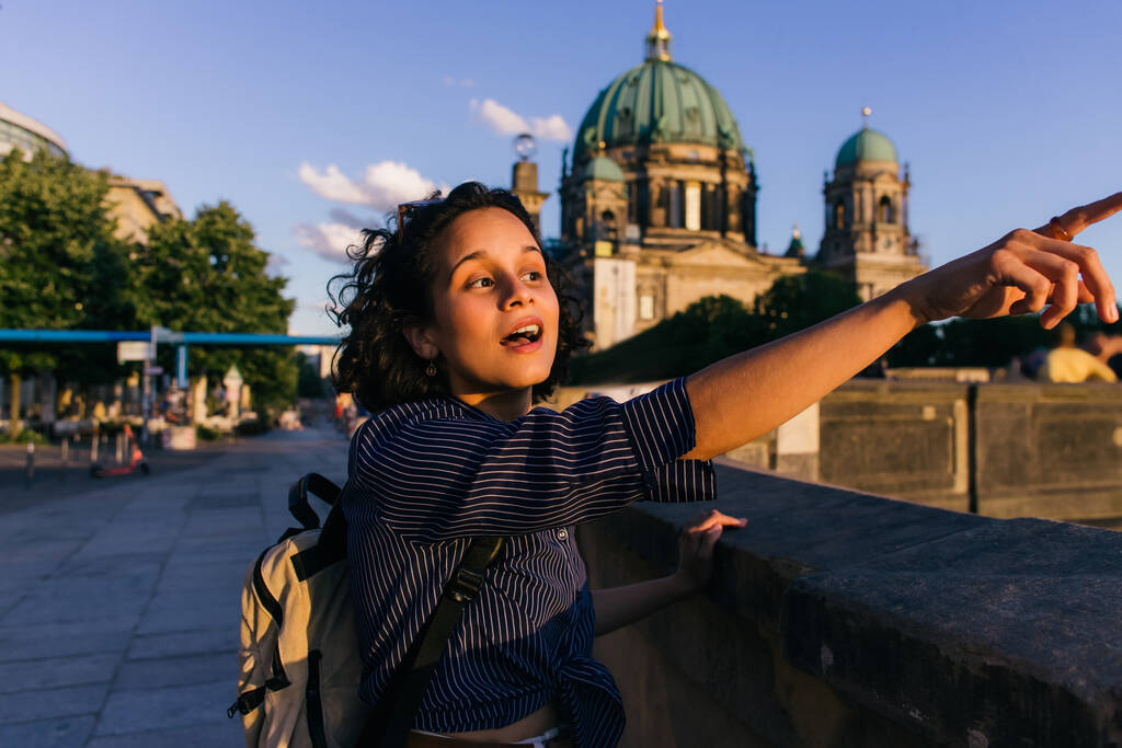 BERLIN, GERMANY - JULY 14, 2020: amazed young woman pointing away near blurred berlin cathedral - Valokuva, kuva