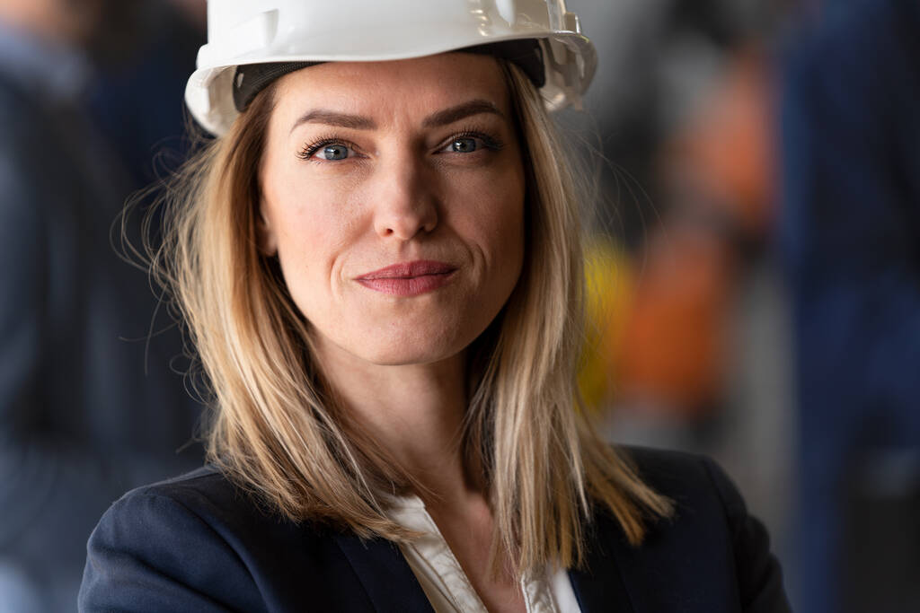 Portret kobiety głównego inżyniera we współczesnej fabryce przemysłowej patrzącej w kamerę. - Zdjęcie, obraz
