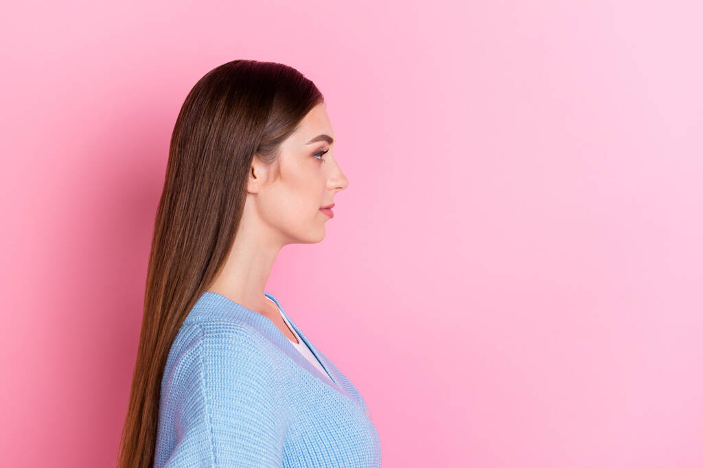 Profile side photo of pretty stylish girlish woman with long smooth hairdo looking empty space isolated on pink color background. - Foto, immagini