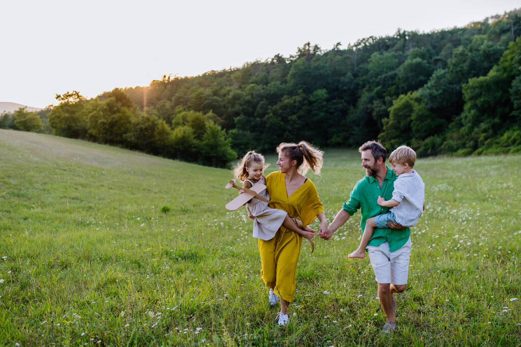 A happy young family spending time together outside in green nature. - Foto, imagen