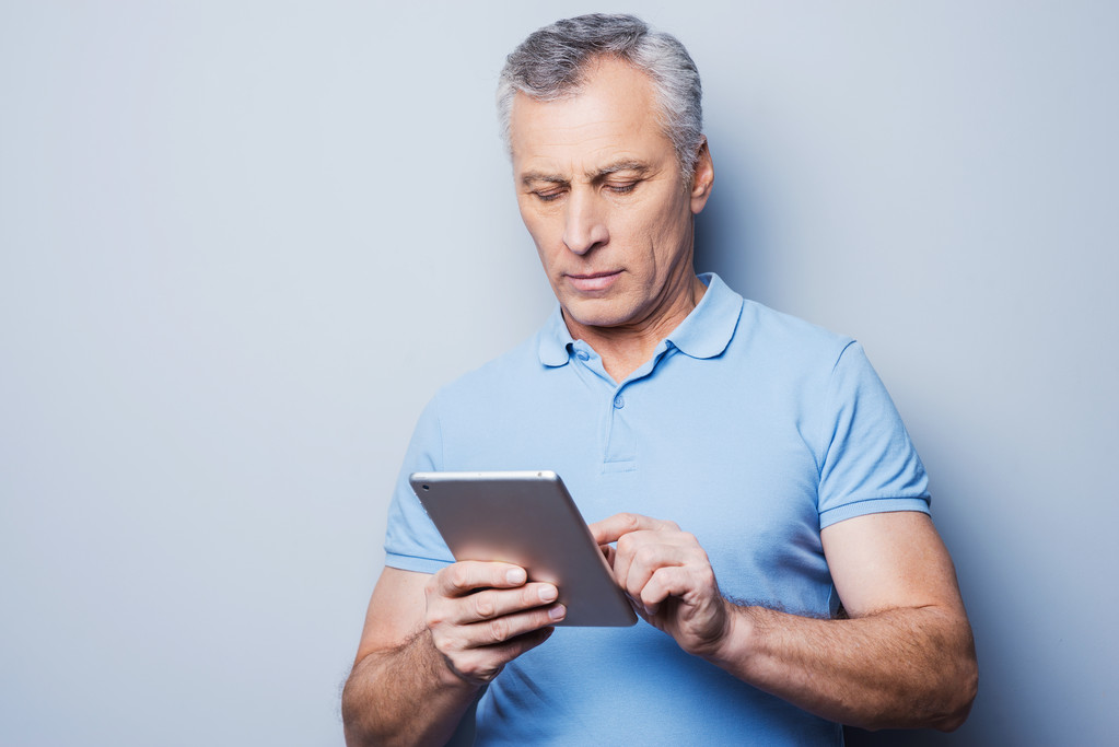 Senior homme travaillant sur sa tablette numérique
 - Photo, image