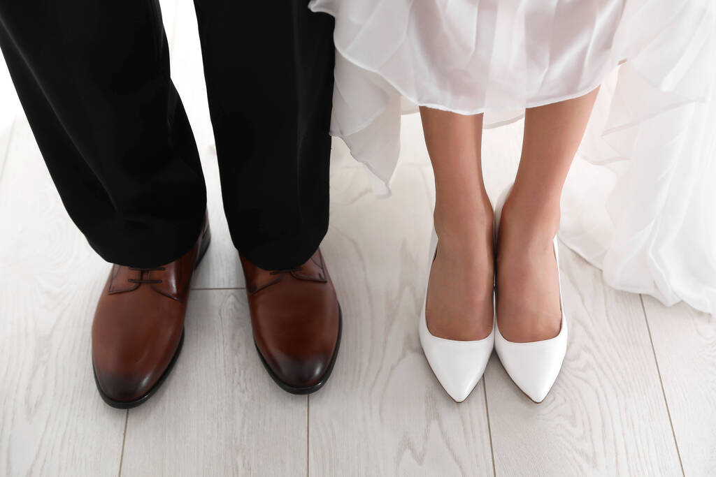 Bride and groom wearing elegant classic wedding shoes indoors, closeup - Photo, Image