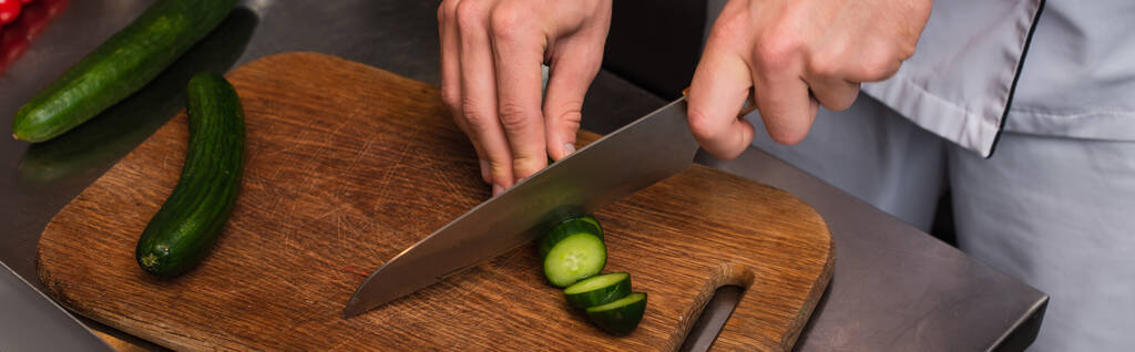 обрізаний вид шеф-кухаря, що ріже огірок на дерев'яній обробній дошці, банер
 - Фото, зображення