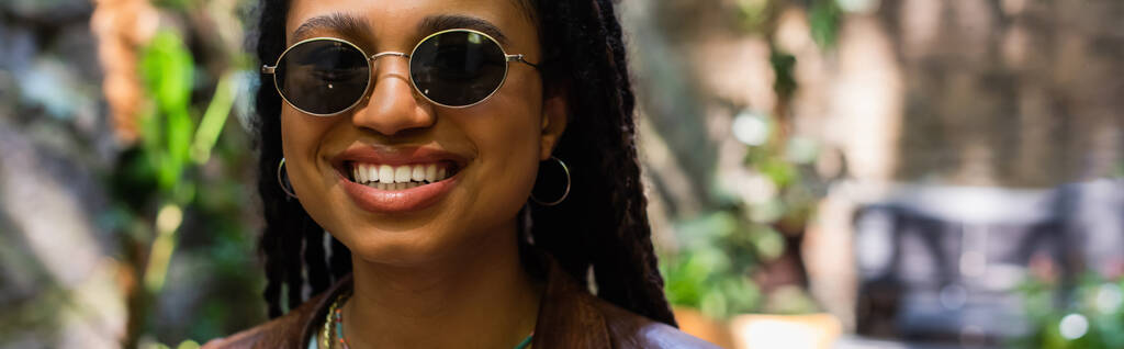 portrait of happy african american woman in sunglasses smiling outside, banner - Photo, Image