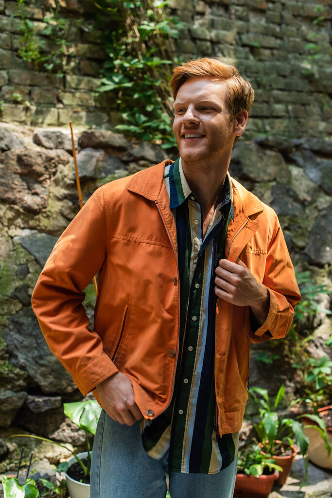 happy redhead man in orange jacket smiling outside - Fotografie, Obrázek