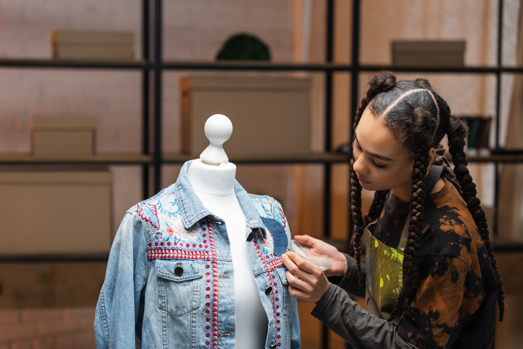 Африканский американский дизайнер украшает джинсовую куртку в мастерской  - Фото, изображение