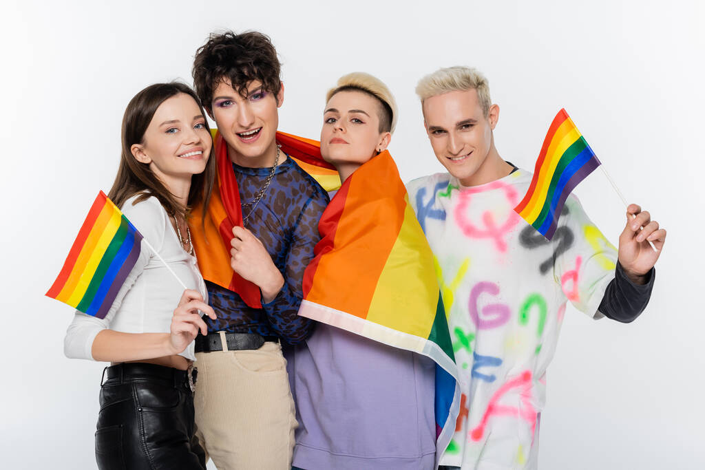 smiling lgbtq community people with rainbow flags looking at camera isolated on grey - Fotografie, Obrázek
