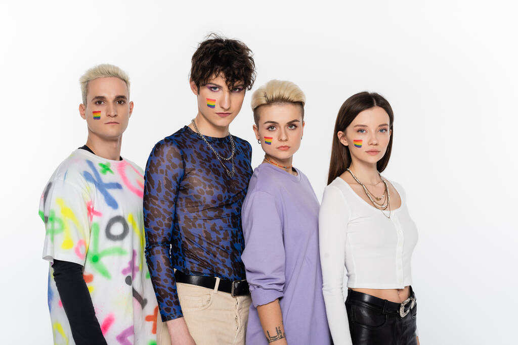 young friends with lgbtq flags on faces looking at camera isolated on grey - Fotografie, Obrázek