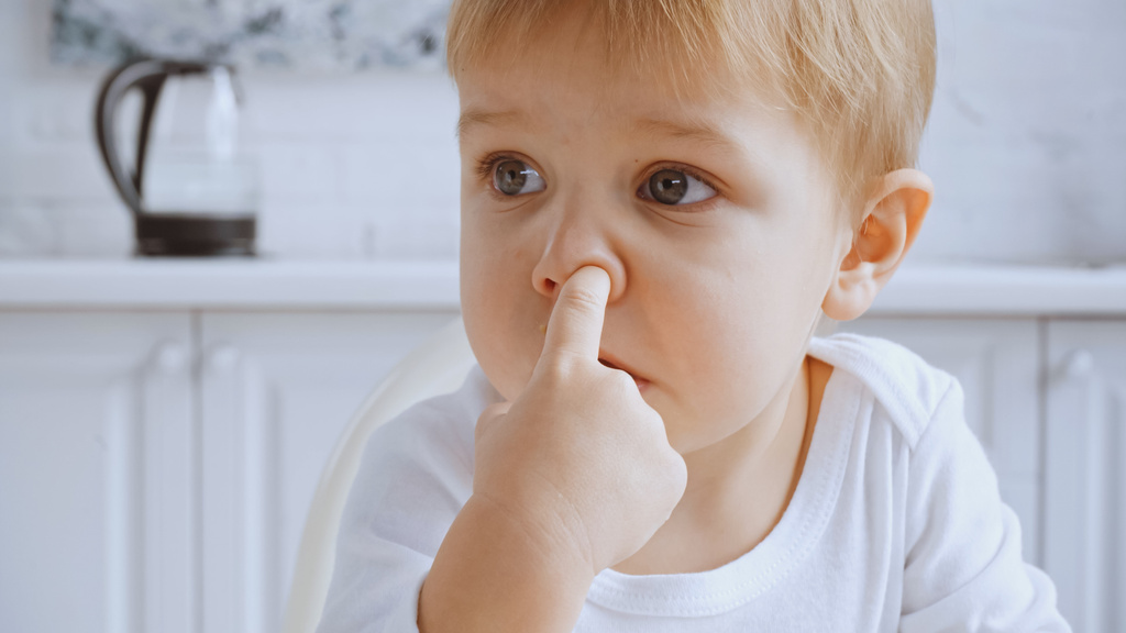 close up of naughty toddler boy picking his nose and looking away - Valokuva, kuva