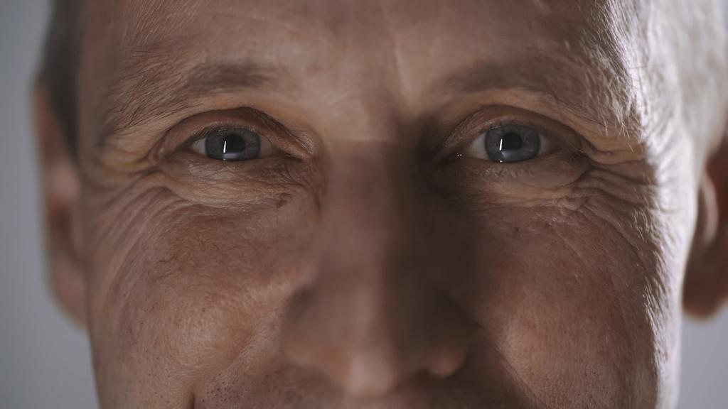 close up view of happy middle aged man with wrinkles looking at camera isolated on grey  - Foto, immagini