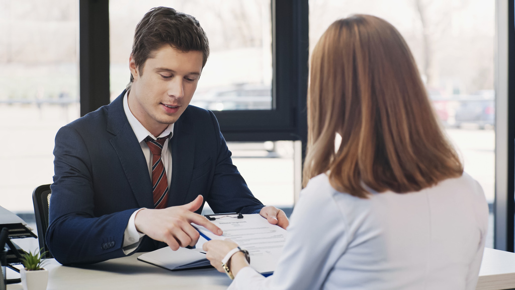 man pointing at resume during job interview with businesswoman in office - Photo, Image