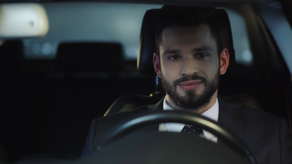 young and positive businessman traveling in auto at night - Φωτογραφία, εικόνα
