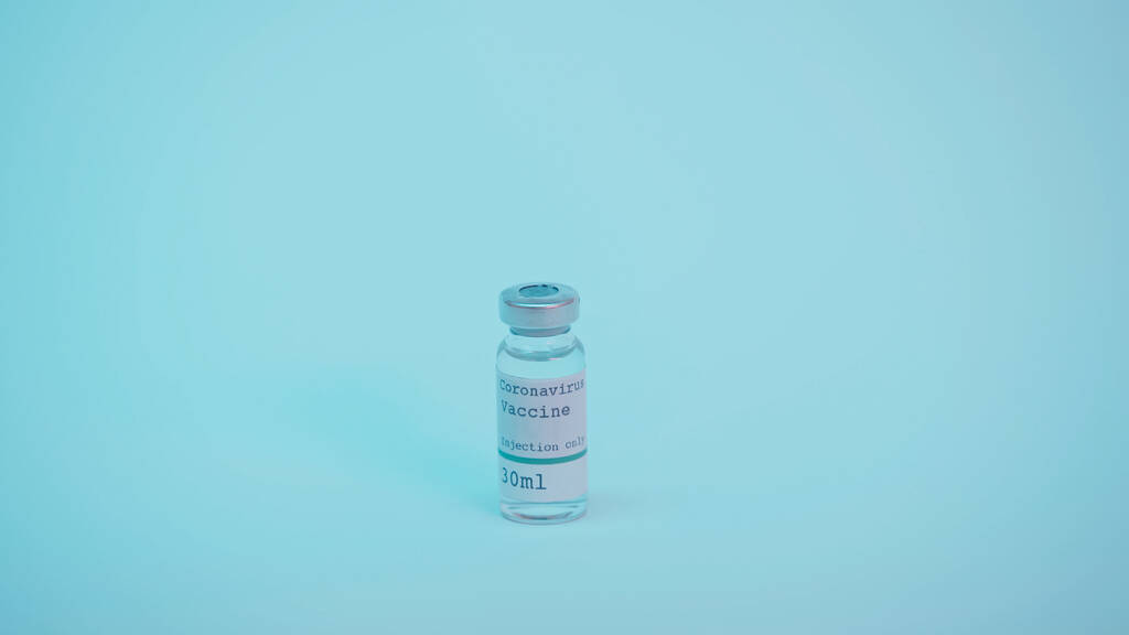 glass bottle with coronavirus vaccine and injection only lettering on blue  - 写真・画像