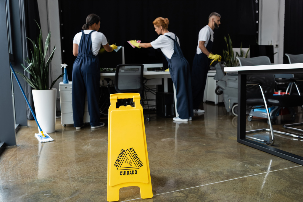 letrero de atención cerca de equipo profesional multiétnico limpieza oficina moderna  - Foto, Imagen