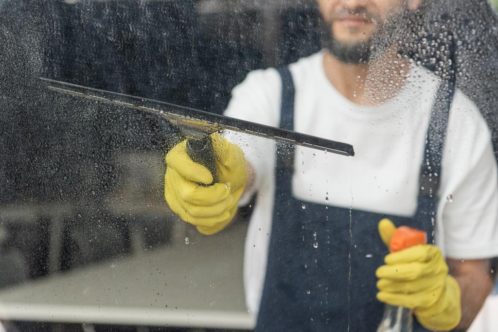 vágott kilátás ember mosószer és ablaktörlő üveg az irodában - Fotó, kép