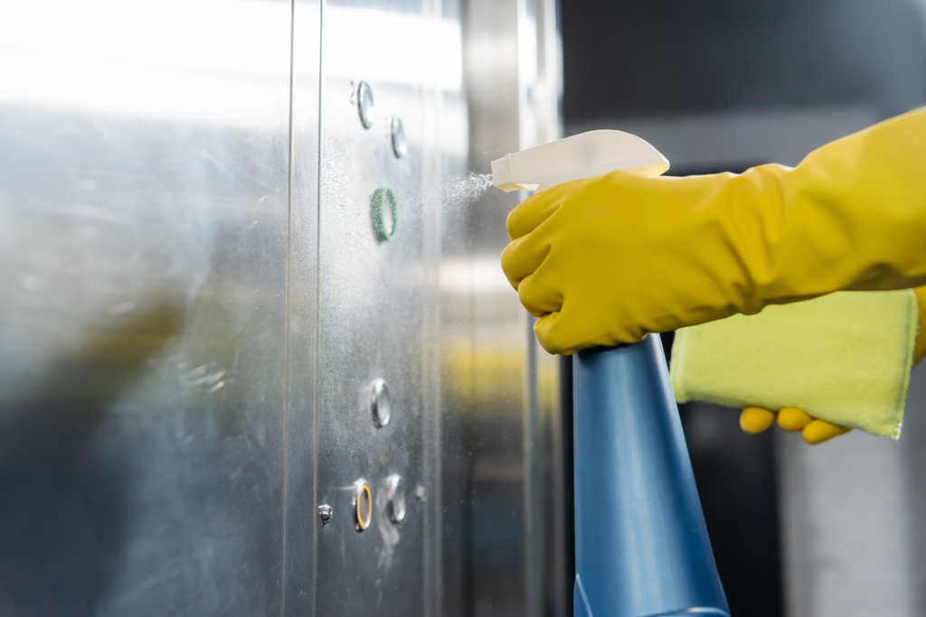 Ofis asansörünü yıkarken deterjan spreylemenin kısmi görüntüsü - Fotoğraf, Görsel