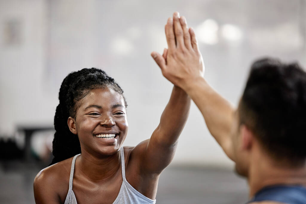 High five, fitness team and gym success of friends in happy exercise workout together for health and wellness. Black woman with smile, excited and goal in teamwork celebration with her training coach. - Foto, Imagem