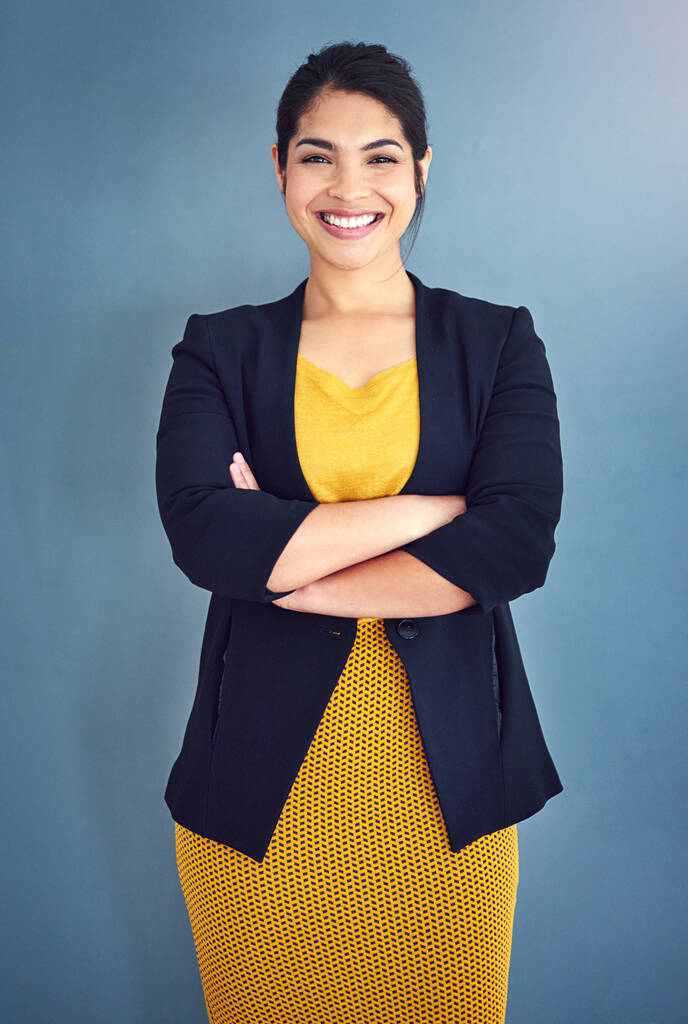Zaufanie jest kluczem do sukcesu. Studio portret atrakcyjnej młodej bizneswoman stojącej na niebieskim tle - Zdjęcie, obraz