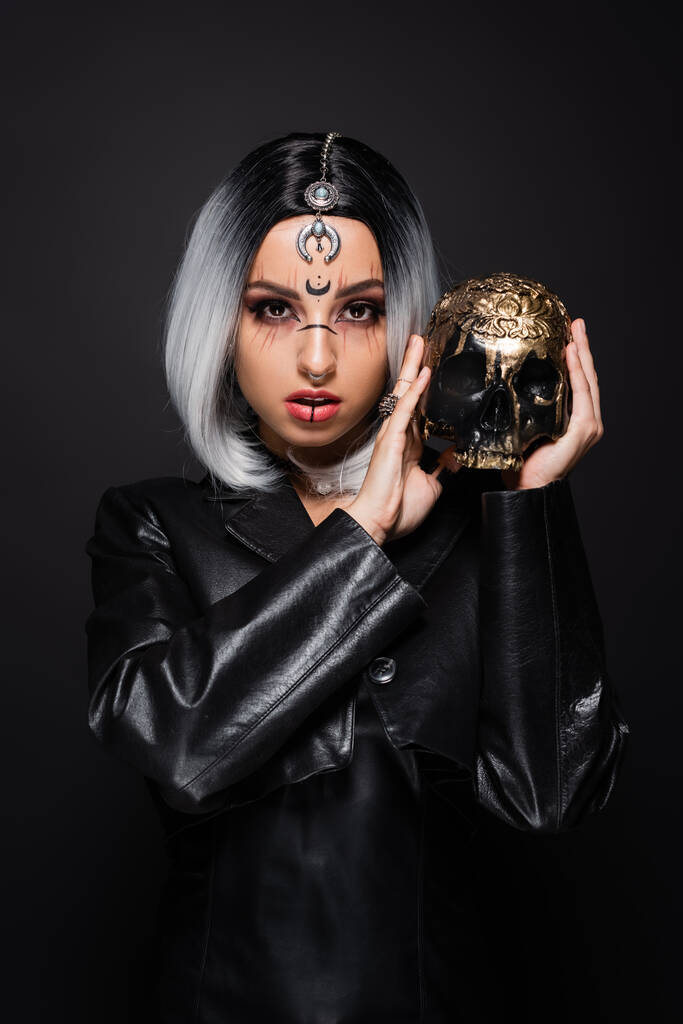 セクシーashブロンド女性で魔女衣装を保持金の頭蓋骨孤立オン黒 - 写真・画像