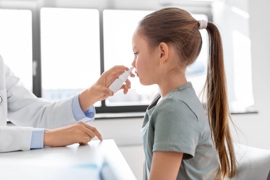medicine, healthcare and pediatry concept - female doctor or pediatrician and little girl patient blowing her nose on medical exam at clinic - Zdjęcie, obraz