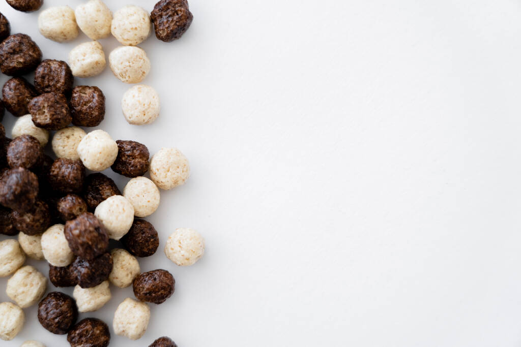 Beyaz üzerine izole edilmiş vanilya ve çikolata aromalı mısır gevreği toplarının üst görüntüsü  - Fotoğraf, Görsel