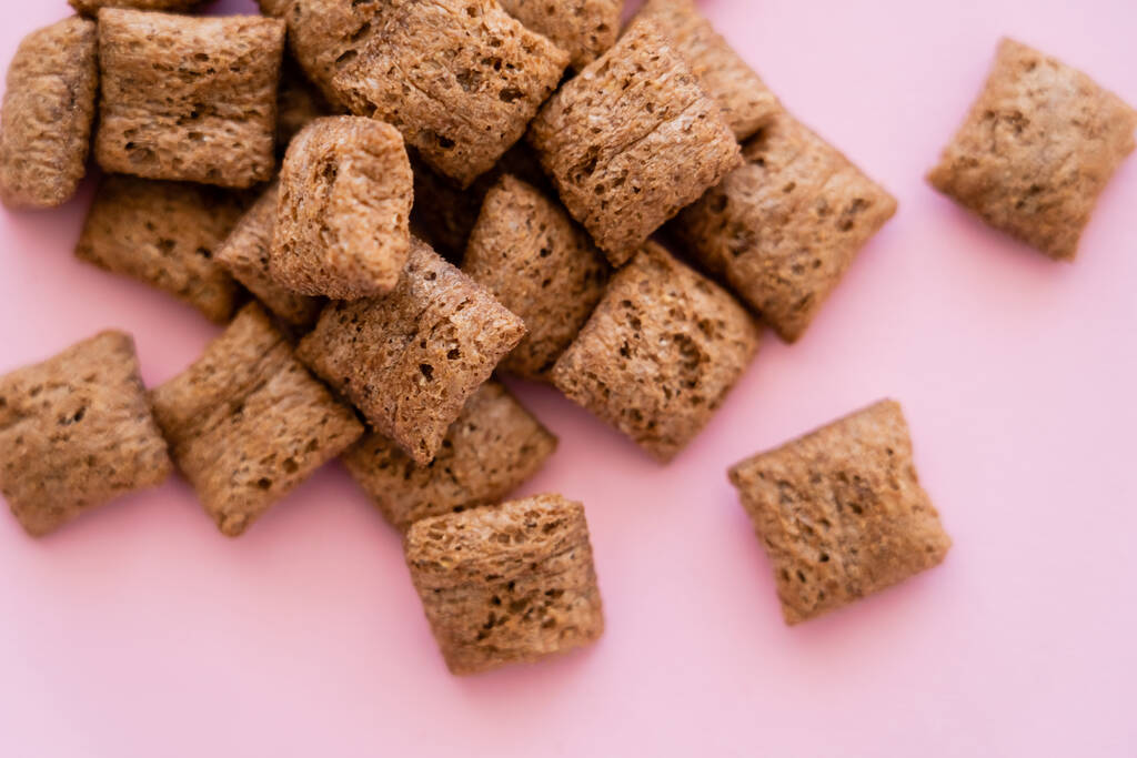 vista superior de las bocanadas de cereales de desayuno aisladas en rosa  - Foto, Imagen