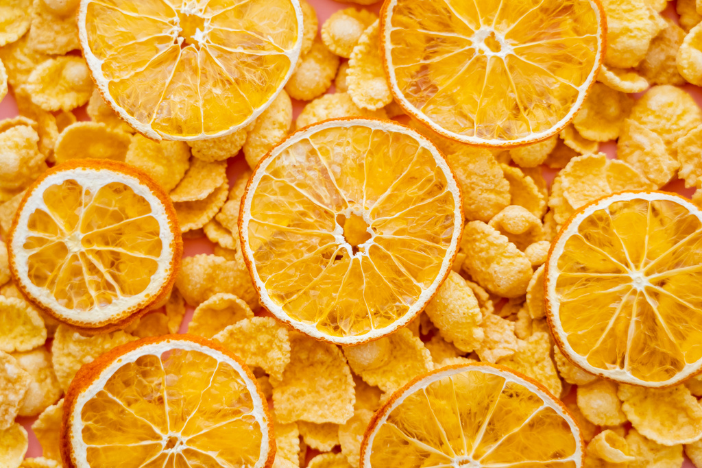 вид зверху на сушені апельсини зверху хрусткого сніданку кукурудзяні пластівці
  - Фото, зображення