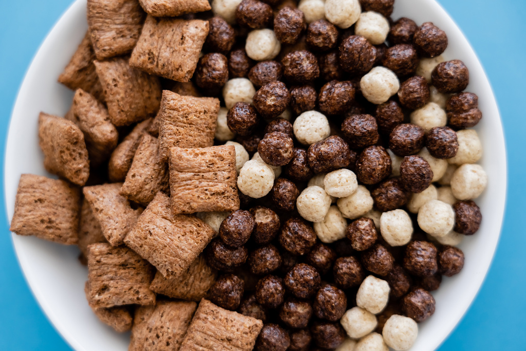 close up view of bowl with tasty cereal balls and puffs isolated on blue - Photo, Image