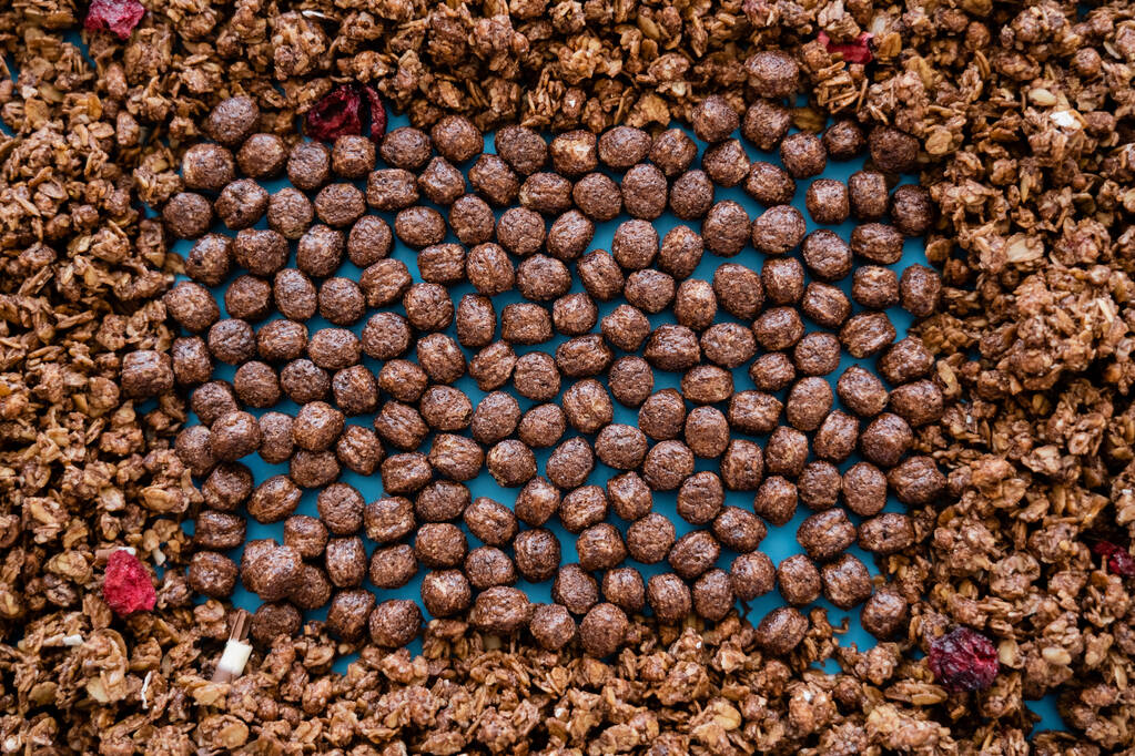 vista dall'alto di gustose palline di cereali vicino alla croccante granola di cioccolato  - Foto, immagini
