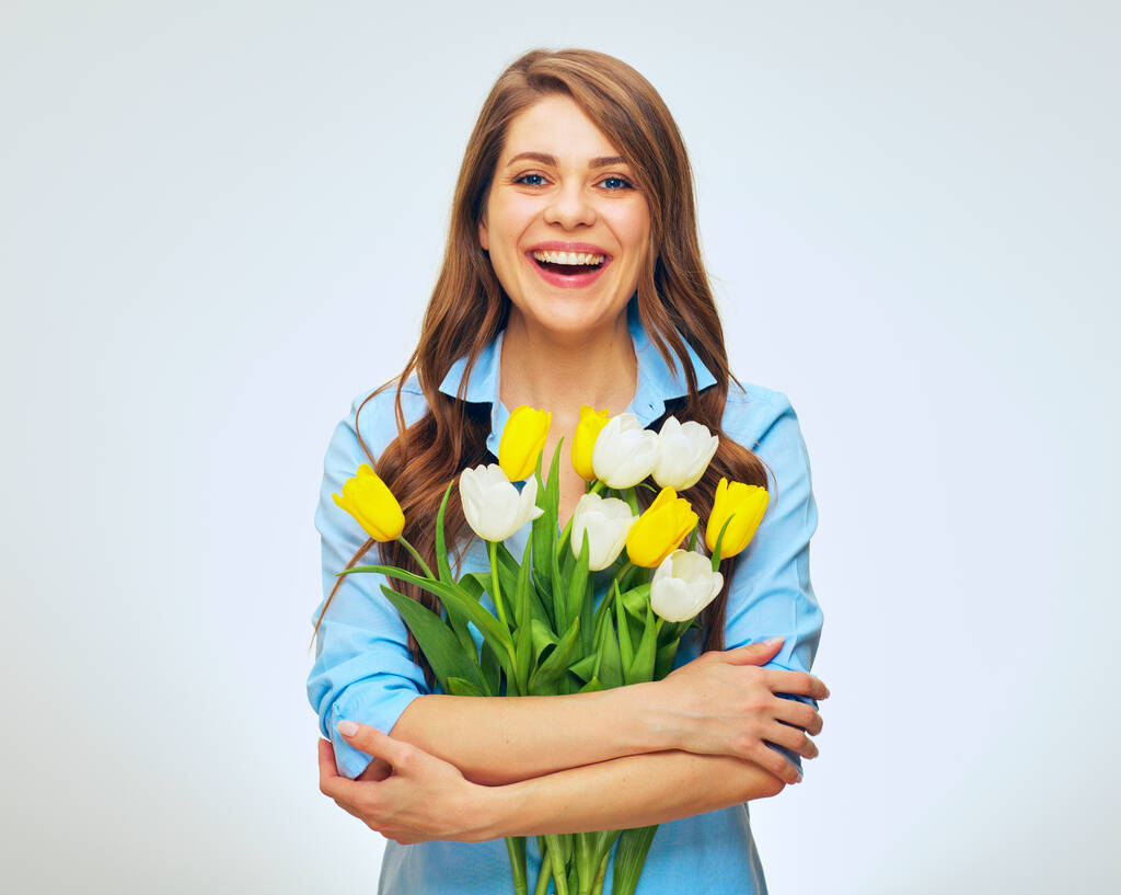 Szczęśliwa kobieta trzyma bukiet kwiatów tulipanów. Odizolowany portret kobiety na białym. - Zdjęcie, obraz