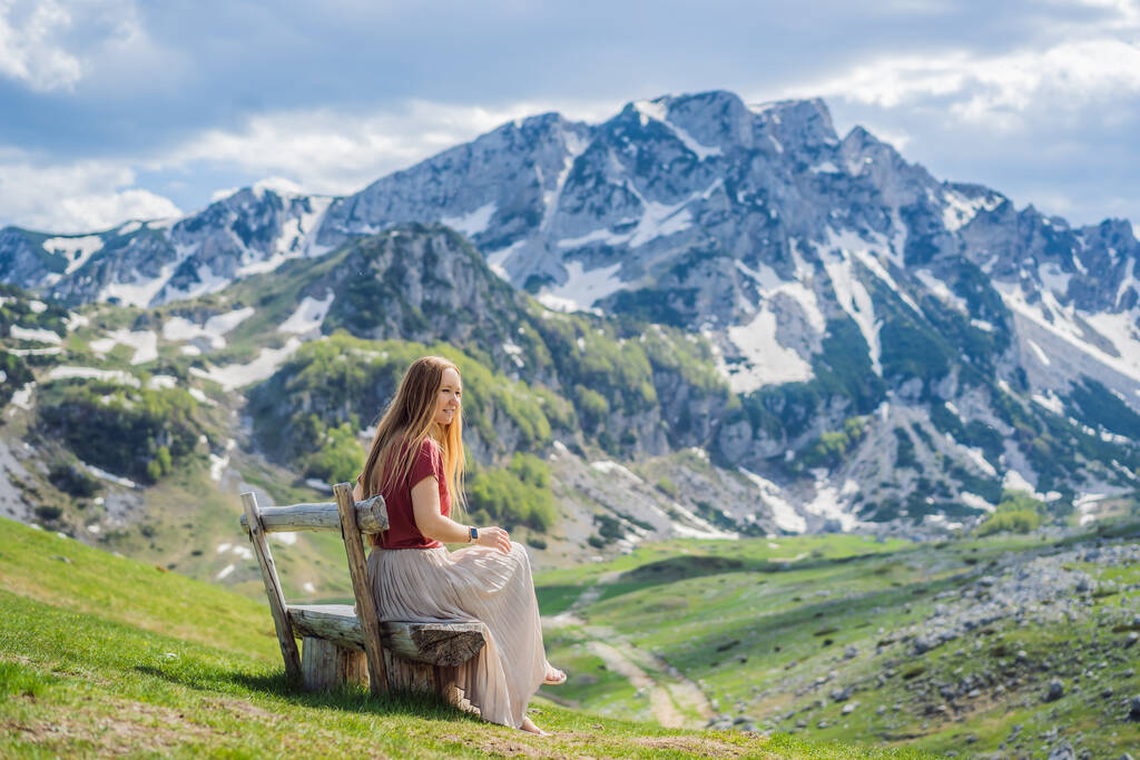Karadağ 'ın Durmitor Dağı' ndaki Dağ Gölü manzarasında kadın turist. Güzel Durmitor Milli Parkı, göl buzulu ve dağları yansıtıyor.. - Fotoğraf, Görsel