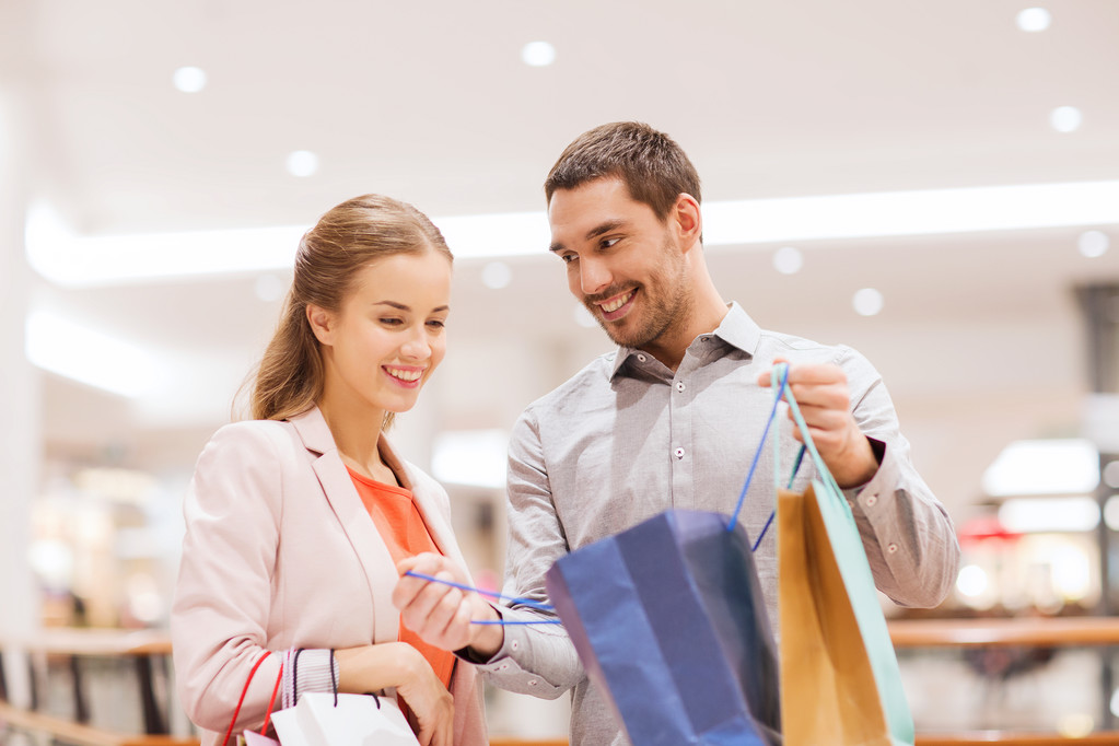 feliz pareja joven con bolsas de compras en el centro comercial
 - Foto, Imagen