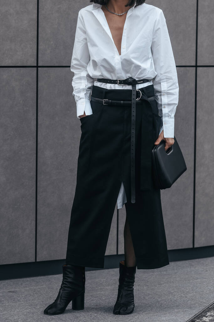 Милан, Италия - 24 февраля: Уличный стиль, женщина в белой рубашке V-образного выреза и черных кожаных брюках. - Фото, изображение