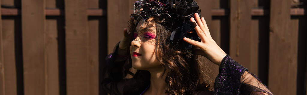 dívka v kostýmu čarodějnice úprava černé věnec venku, prapor - Fotografie, Obrázek