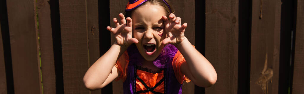 ragazza in costume di Halloween ringhiando e mostrando gesto spaventoso, banner - Foto, immagini