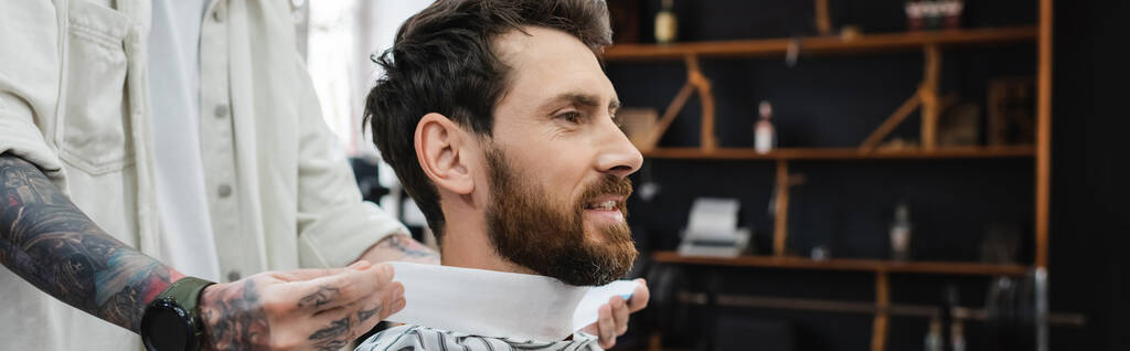 cabeleireiro tatuado colocando colar de cabeleireiro no pescoço do cliente, banner - Foto, Imagem