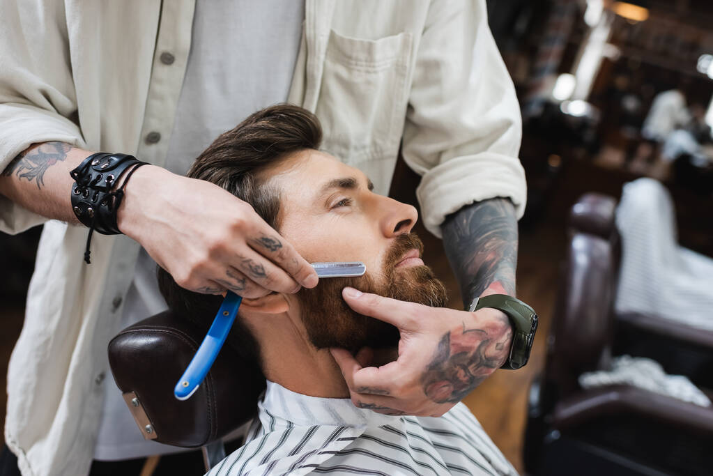 peluquero tatuado afeitado barbudo hombre con navaja de afeitar recta - Foto, imagen