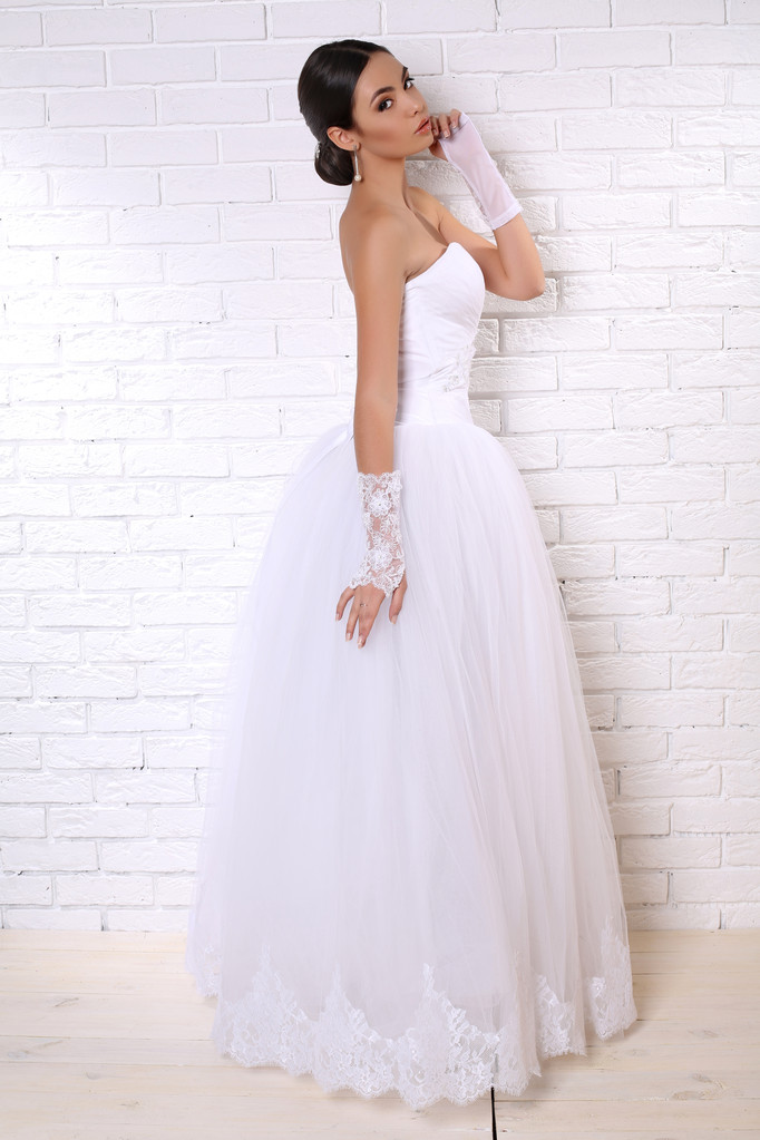 красивая невеста с темными волосами в элегантном свадебном платье с аксессуарами
 - Фото, изображение