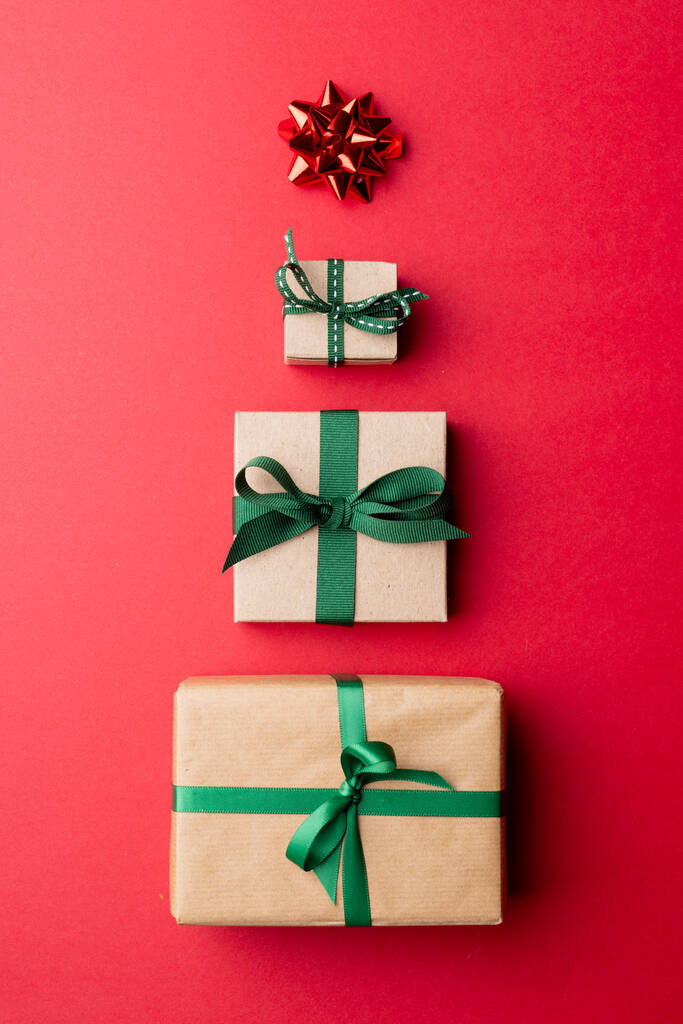 Imagen de regalos de navidad y estrella roja formando árbol de navidad y copiando espacio sobre fondo rojo. Navidad, tradición y concepto de celebración. - Foto, imagen