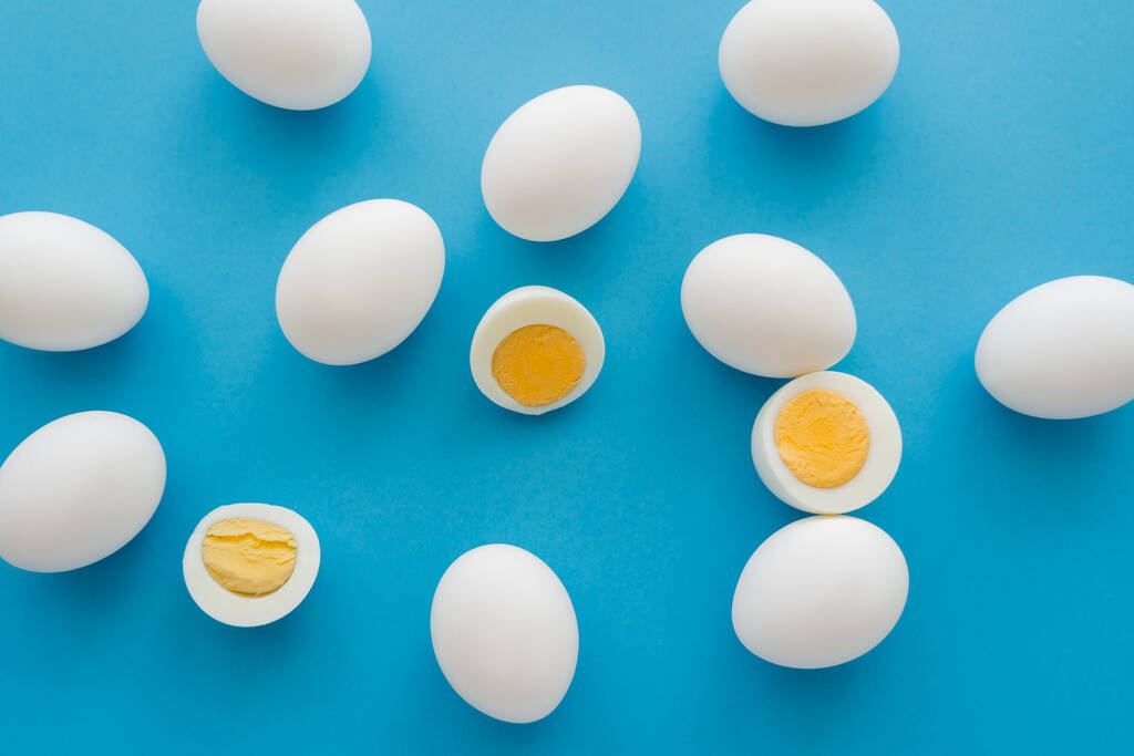 Vista superior de los huevos cocidos en la superficie azul  - Foto, imagen