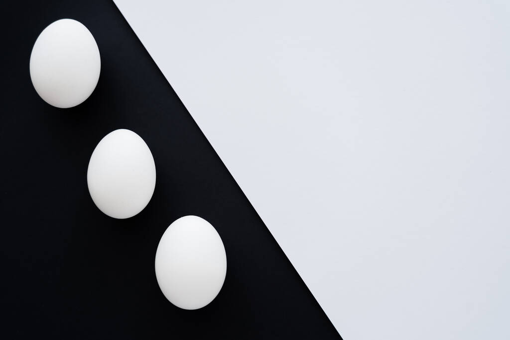 Widok z góry naturalnych jaj kurzych na białym i czarnym tle  - Zdjęcie, obraz