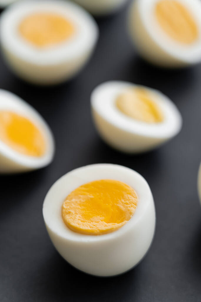 Close up view of cut boiled chicken egg on black background  - Photo, Image