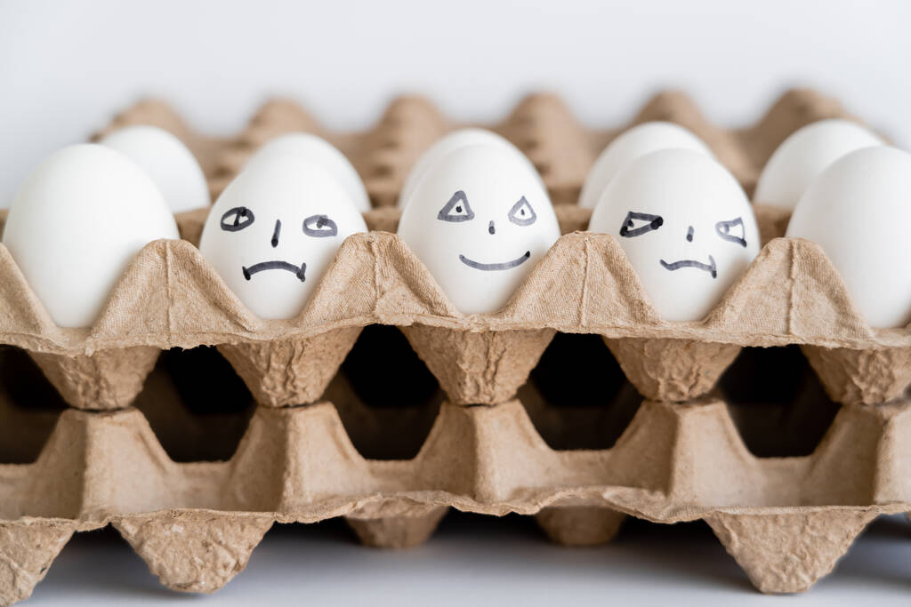 Maalatut munat, joilla on erilaiset ilmeet pahvilaatikoissa valkoisella pohjalla  - Valokuva, kuva