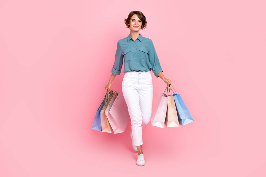 Foto de longitud completa de la señora bonita traje de moda de dos brazos llevar bolsa de mano disfrutar de compras aislado en el fondo de color rosa. - Foto, imagen