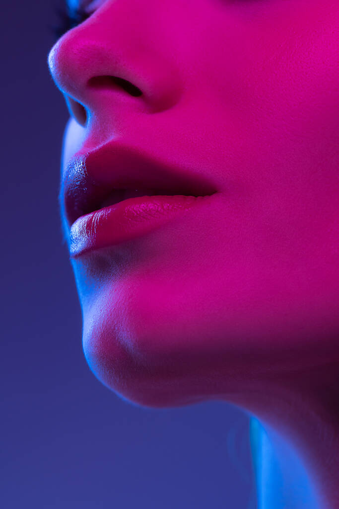 Smile. Closeup female lips, cheeks and nose isolated over dark background in neon light. Natural beauty. Concept of natural beauty, cosmetology, skincare, cosmetics, plastic surgery, ad - Foto, Imagem