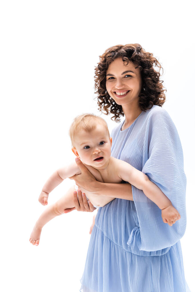 Hymyilevä nainen sininen mekko tilalla vauva tyttö eristetty valkoinen  - Valokuva, kuva