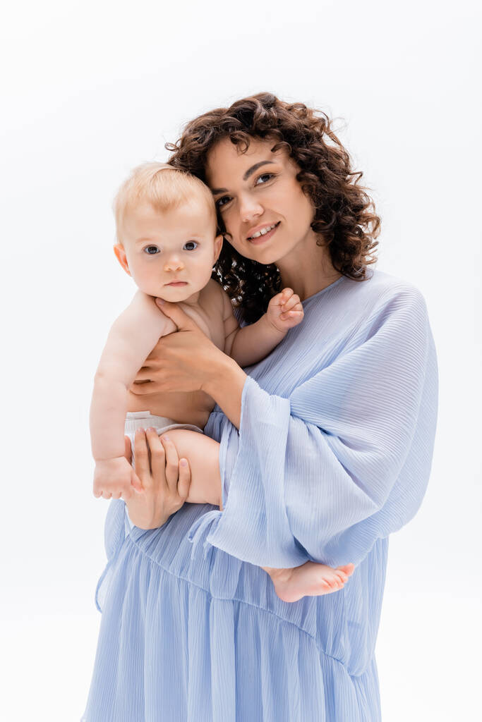 Beyaz kameraya bakan kıvırcık anne ve bebek kızı portresi  - Fotoğraf, Görsel