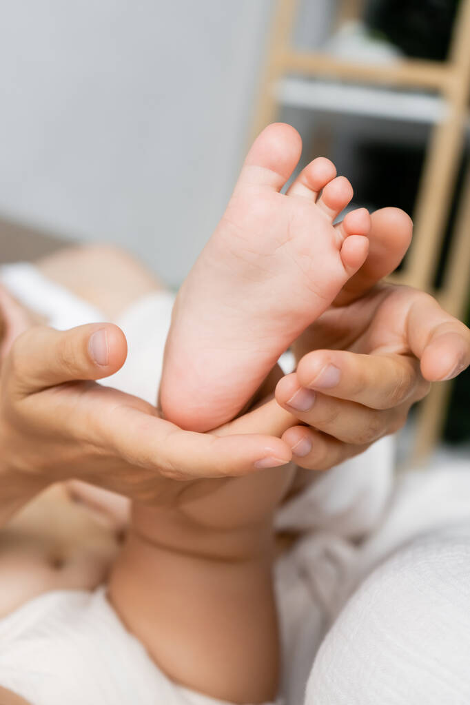 自宅で赤ちゃんの娘の足に触れる親のビュー  - 写真・画像